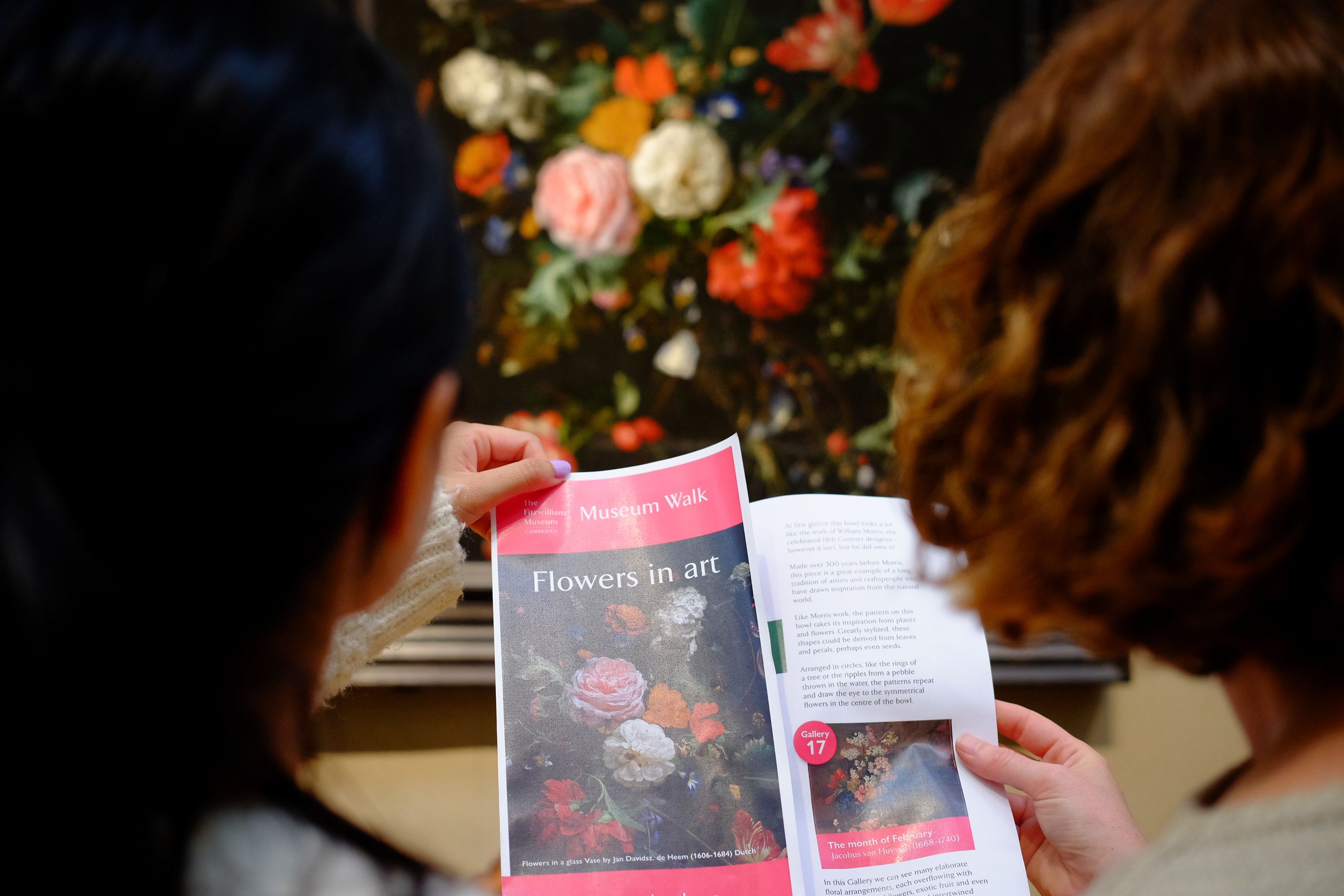 A Museum Walk leaflet about 'Flowers in Art' held up in front of the painting featured on its front cover.
