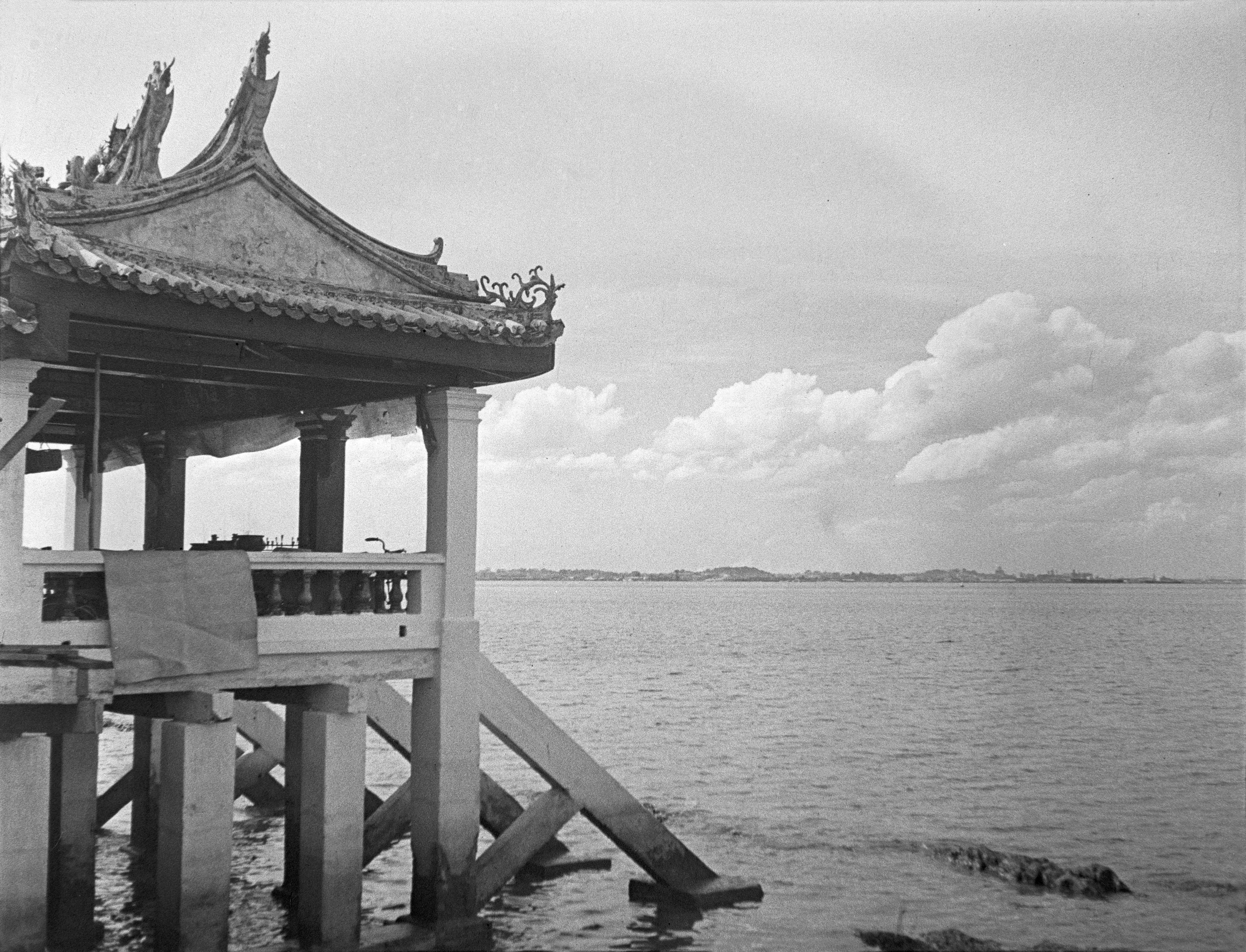 View of the Tua Pek Kong temple at Kusu Island, Singapore. The building stands on stilts at the edge of the sea and has carved wooden roof.